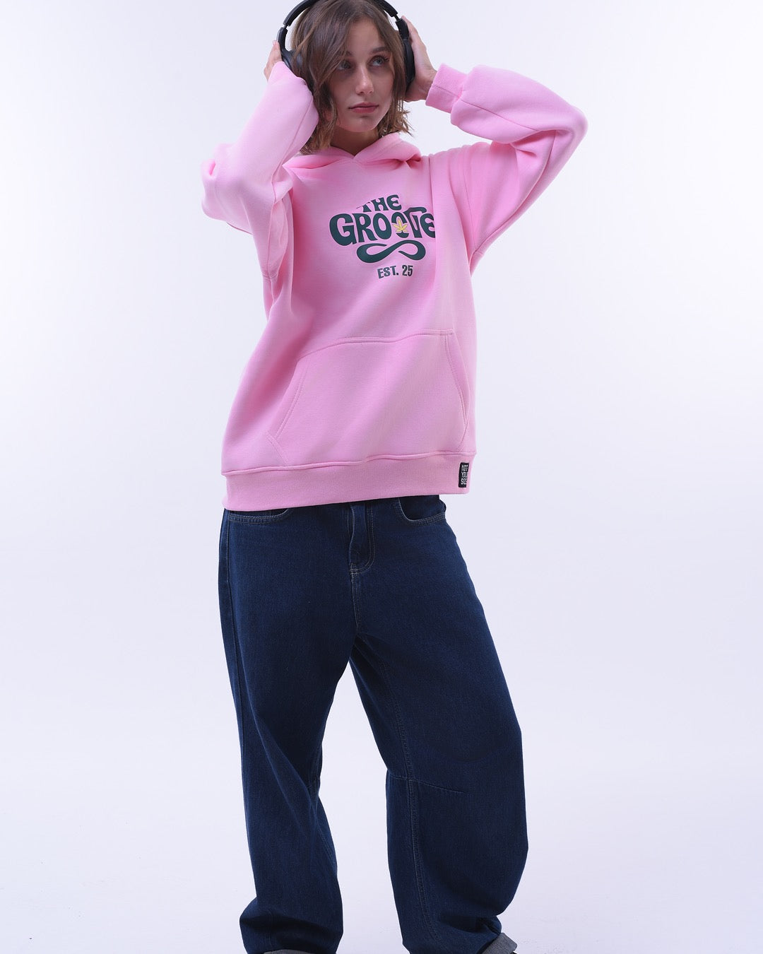 Pink oversized hoodie for women with graphic text paired with dark blue jeans